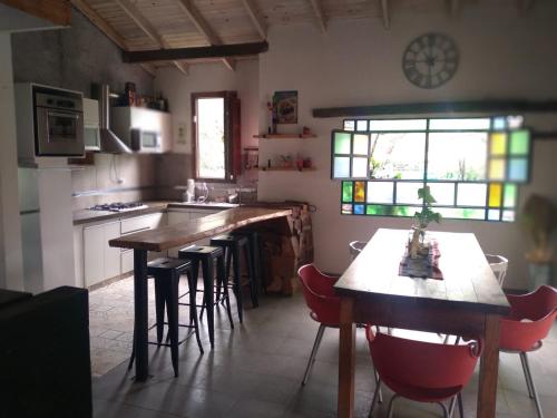 una cocina con mesas y sillas de madera y una ventana en CASONA PINTORESCA en las sierras en San Roque