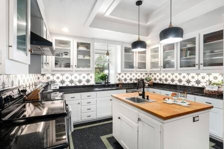 a kitchen with white cabinets and a wooden counter top at The Mint Julep, pet-friendly, hot tub, sleeps 8! in Fredericksburg