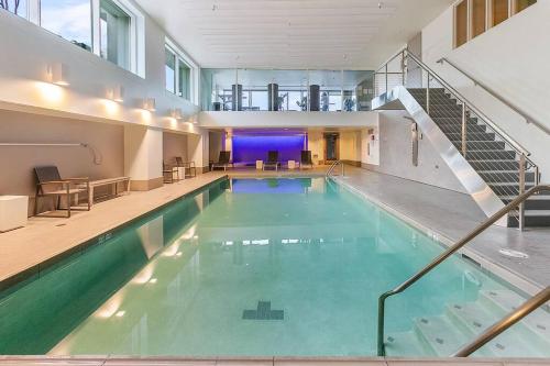 a swimming pool with a staircase in a building at NewMark Tower’s Water Wheel Condo with Sea Views in Seattle