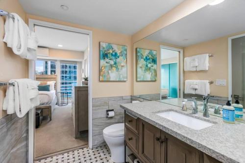 La salle de bains est pourvue d'un lavabo, de toilettes et d'un miroir. dans l'établissement NewMark Tower’s Water Wheel Condo with Sea Views, à Seattle