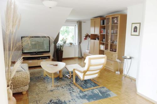 a living room with a chair and a television at FEWO EMMA in Overath