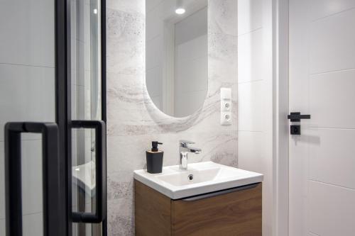 een badkamer met een wastafel en een spiegel bij Old Town Apartment Kazimierz in Krakau