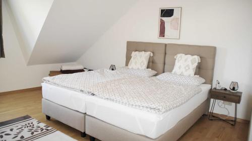 a bedroom with a large white bed in a room at FEWO EMMA in Overath