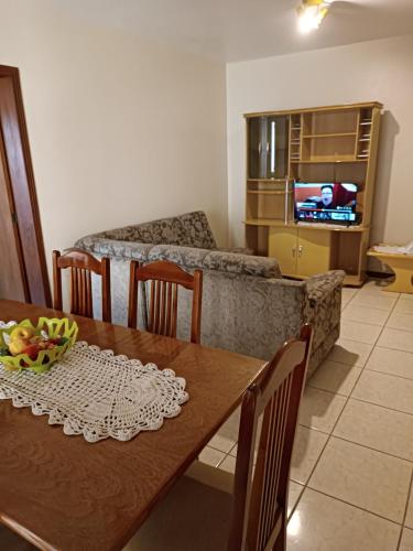 ein Wohnzimmer mit einem Tisch und einem Sofa in der Unterkunft Apto grande em Camobi in Santa Maria