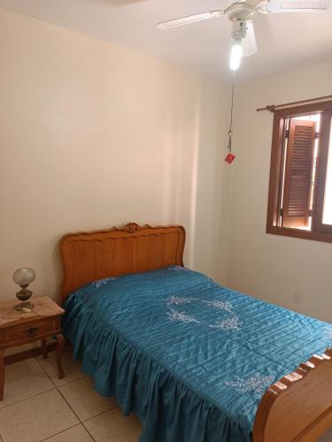 a bedroom with a bed with a blue comforter at Apto grande em Camobi in Santa Maria