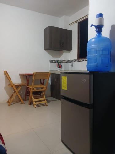 eine Küche mit einer blauen Flasche auf dem Kühlschrank in der Unterkunft 3 Floor Seawiew in Montañita