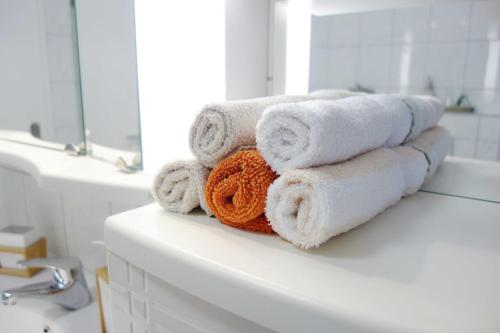 - une pile de serviettes assises au-dessus d'un lavabo dans l'établissement FEWO EMMA, à Overath
