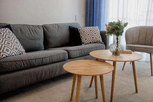 Sala de estar con sofá gris y 2 mesas en Bright 2 Bedroom 2 Bath Apartment close to sea en St Paul's Bay