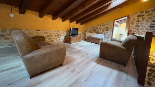 een woonkamer met 2 stoelen en een televisie bij La Caseta in Arnés