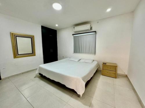 - une chambre avec un lit blanc et une fenêtre dans l'établissement CASA DE HUÉSPEDES FUMINAYA, à Uribia
