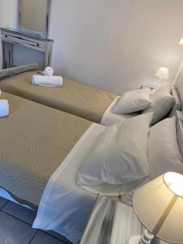 a bedroom with two beds with white pillows at ARTEMIS beach studios in Kalamaki Heraklion