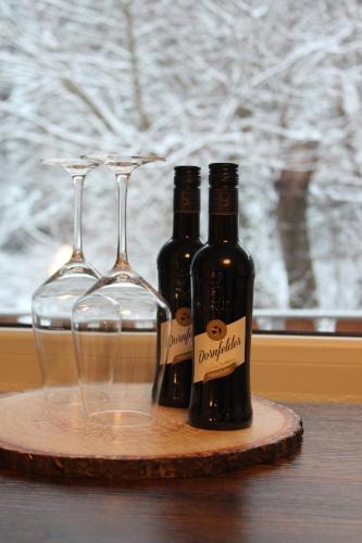 ヴァルメンシュタイナハにあるWaldpension Pfeiferhausの- テーブルの上にボトル2本とワイングラス2本