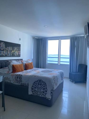 ein Schlafzimmer mit einem Bett und einem großen Fenster in der Unterkunft APTO ESTUIO 11 in Cartagena de Indias