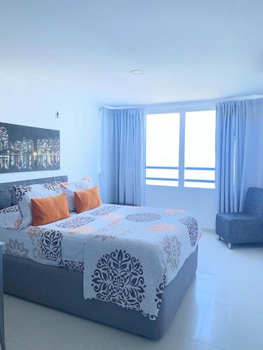 ein blaues Schlafzimmer mit einem Bett und einem Stuhl in der Unterkunft APTO ESTUIO 11 in Cartagena de Indias