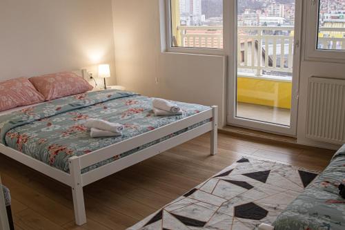 - une chambre avec un lit et une grande fenêtre dans l'établissement Apartment Forever, à Tuzla