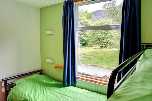 a bedroom with two beds and a window with a view at YHA Borrowdale in Rosthwaite