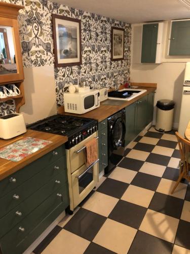 a kitchen with a black and white checkered floor at Bats by the Sea at Number 23 in Scarborough