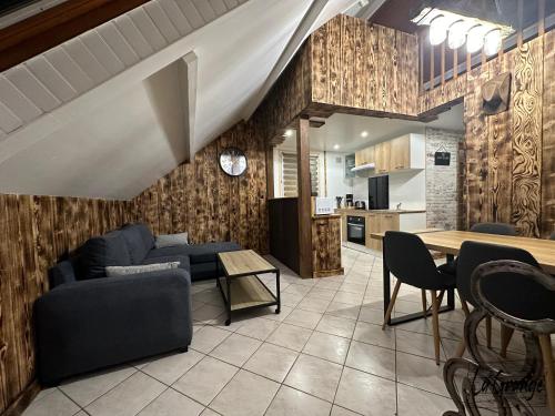 ein Wohnzimmer mit einem Sofa und einem Tisch in der Unterkunft La Grange in Carentan