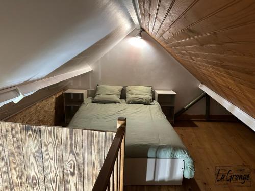 ein Schlafzimmer mit einem Bett im Dachgeschoss in der Unterkunft La Grange in Carentan