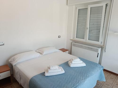 una camera da letto con un letto e asciugamani su un tavolo di Casa D'Elia a Riccione