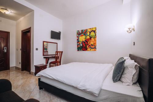 ein Schlafzimmer mit einem weißen Bett und einem Stuhl in der Unterkunft Lihnidos Square in Ohrid