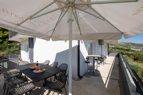un tavolo e sedie sotto un ombrellone su un balcone di Apartment Under the Rock a Spalato (Split)