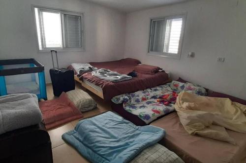 a room with three beds and bags in it at Kosher 'Villa Rosa' Moshav Aderet, Ella Valley nr Bet Shemesh in Adderet