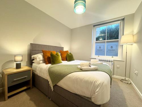 a bedroom with a large bed and a window at The Coppersmith - Warehouse Apartments, Lake District in Ulverston