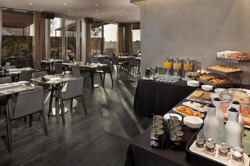 a restaurant with tables and chairs with food on them at ME Milan Il Duca in Milan
