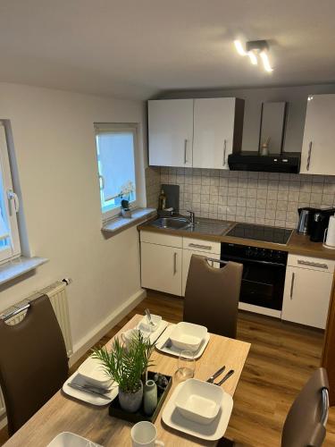 a kitchen with a wooden table with chairs and a dining room at Ferienwohnung Eislingen in Eislingen