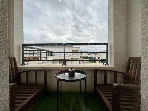 d'un balcon avec une table et une vue sur un bâtiment. dans l'établissement Résidence Les Jardins d'Eugénie Near Disneyland, à Ferrières-en-Brie