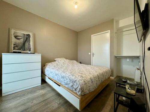 een slaapkamer met een bed, een dressoir en een lade bij Résidence Les Jardins d'Eugénie Near Disneyland in Ferrières-en-Brie