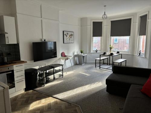 a living room with a couch and a tv at Urban Heights, Central BH1 in Bournemouth