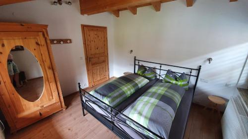 um quarto com uma cama com almofadas verdes e azuis em Ferienhaus Ulla em Reit im Winkl