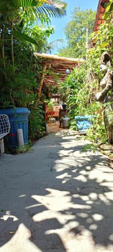 a walkway with a wooden pergola and plants at Vila Santa Rosa Guest House in Ilhabela
