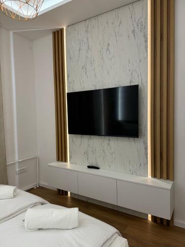 a living room with two beds and a television on a wall at Mona Luxury Apartments - Free Garage Parking in Sarajevo
