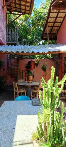 a patio with a table and chairs and an umbrella at Vila Santa Rosa Guest House in Ilhabela