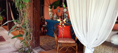 a room with a chair and a curtain at Vila Santa Rosa Guest House in Ilhabela