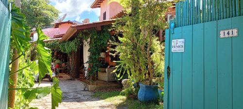a house with a blue gate in a yard at Vila Santa Rosa Guest House in Ilhabela