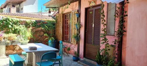 a small patio with a table and chairs next to a building at Vila Santa Rosa Guest House in Ilhabela