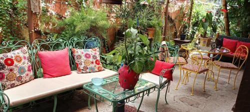 a bench with colorful pillows and a table and chairs at Vila Santa Rosa Guest House in Ilhabela