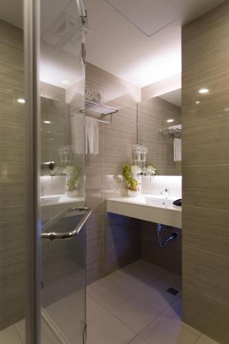 a bathroom with a glass shower and a sink at 麗馨商旅七賢館 in Kaohsiung