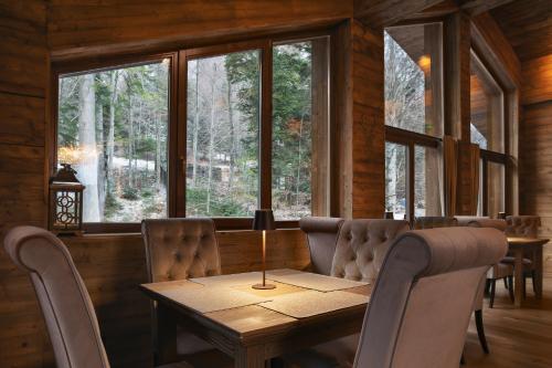 a dining room with a table and chairs and windows at Chalet Royal in Sinaia