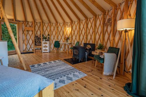 a room with a bed and a fireplace in a yurt at Mononoke -Jurty nad Sanem in Lutowiska