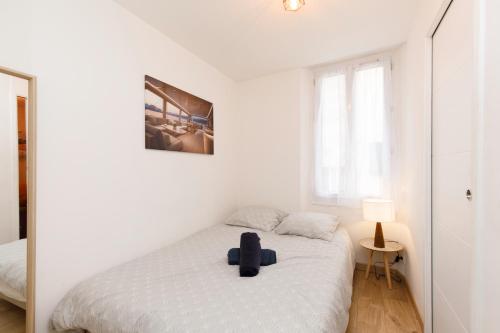 - une chambre blanche dotée d'un lit avec un siège bleu dans l'établissement The Yachting - Host Provence, au Cannet