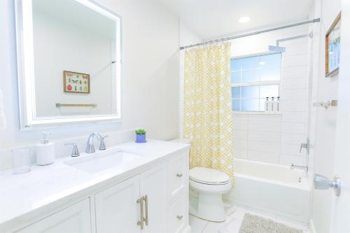 a bathroom with a sink and a toilet and a shower at Magnolia Home • Clearwater Beach • BBQ • Sunroom in Clearwater