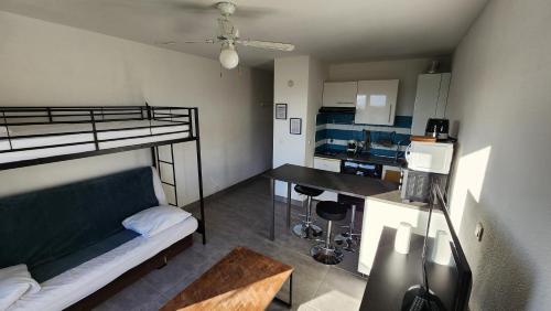 um pequeno quarto com um beliche e uma cozinha em Studio et parking avec plage à 350m em Canet-en-Roussillon