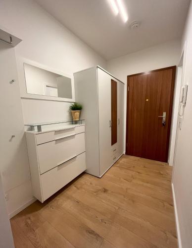 cocina con armarios blancos y suelo de madera en Renoviertes Apartment inkl TG Stellplatz in Düsseldorf en Düsseldorf