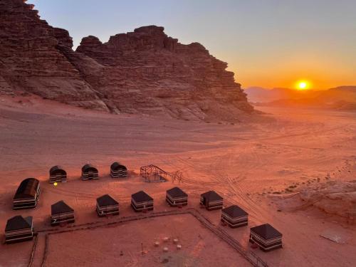 a group of tents in the desert at sunset at um sabatah Camp in Wadi Rum