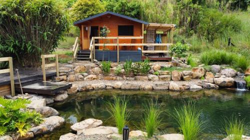 a cabin in a garden with a pond at Tweed Hinterland Eco Cabin in Byangum